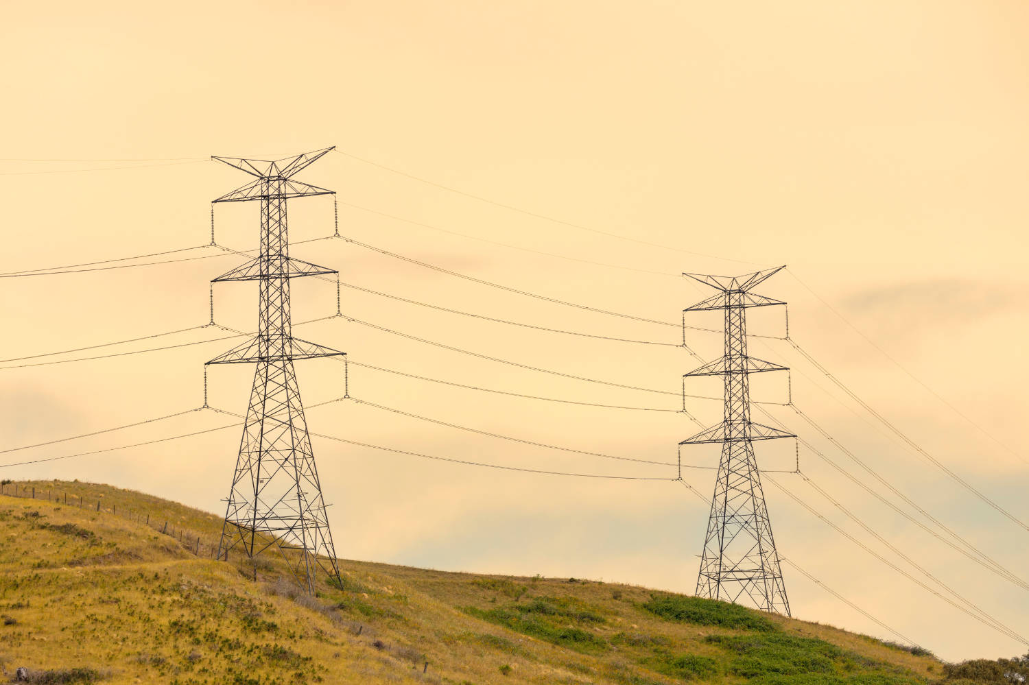 Photograph,Of,A,Large,Electricity,Transmission,Tower,On,A,Grassy